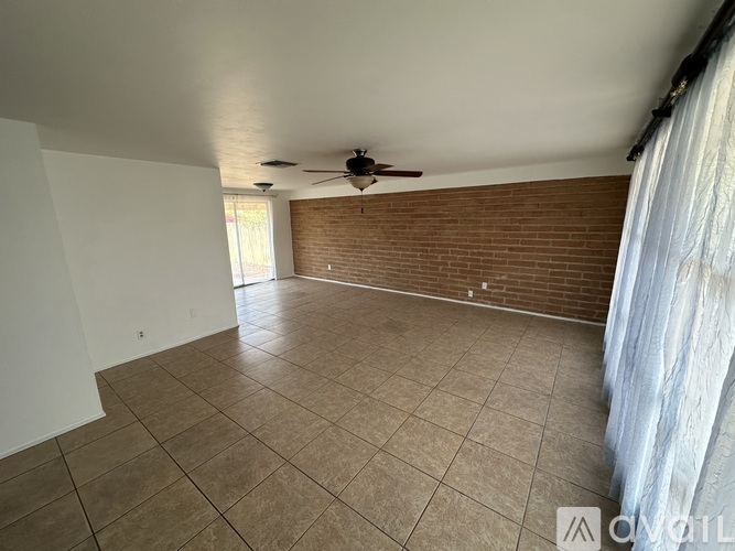 A room with a ceiling fan and tiled flooring.
