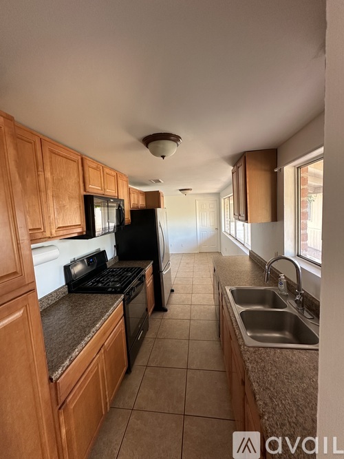 A kitchen with wooden cabinets and a granite countertop.
