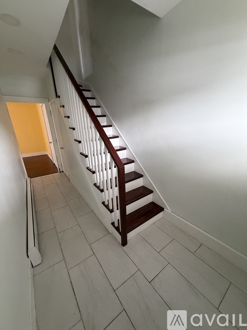 A staircase with white railings and a wooden handrail.