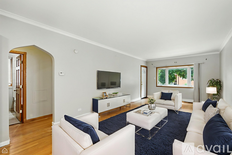 A living room with white furniture and a flat screen TV.
