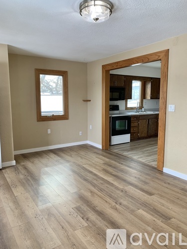 A room with wooden floors and a mirror on the wall.