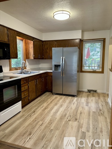 A kitchen with wooden cabinets and a fridge.