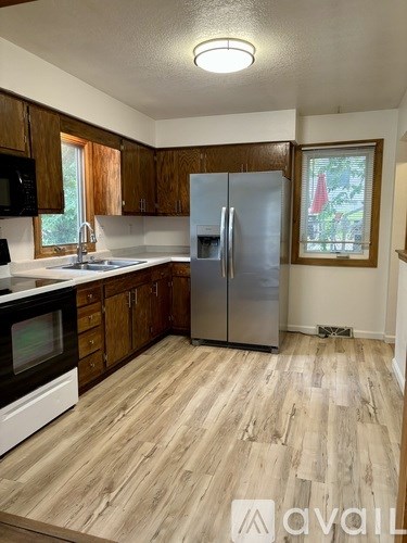A kitchen with wooden cabinets and a fridge.