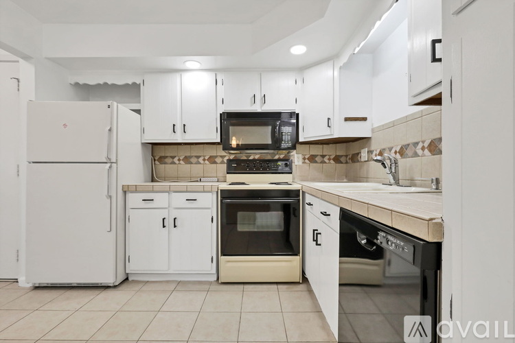 A kitchen with white appliances and cabinets.
