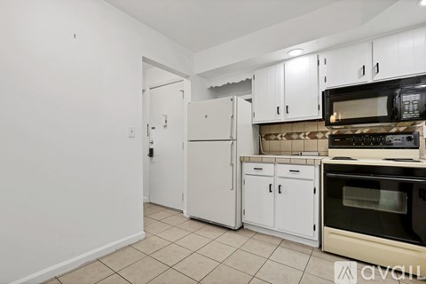 A kitchen with white cabinets and appliances.