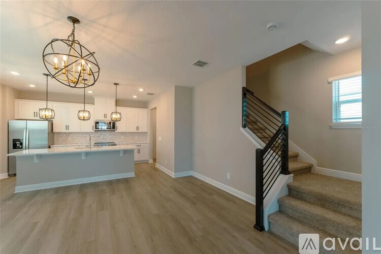 A spacious living room with a staircase leading to the upper floor.
