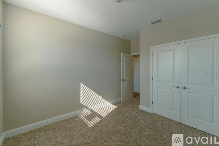 A room with a carpeted floor and a white door.
