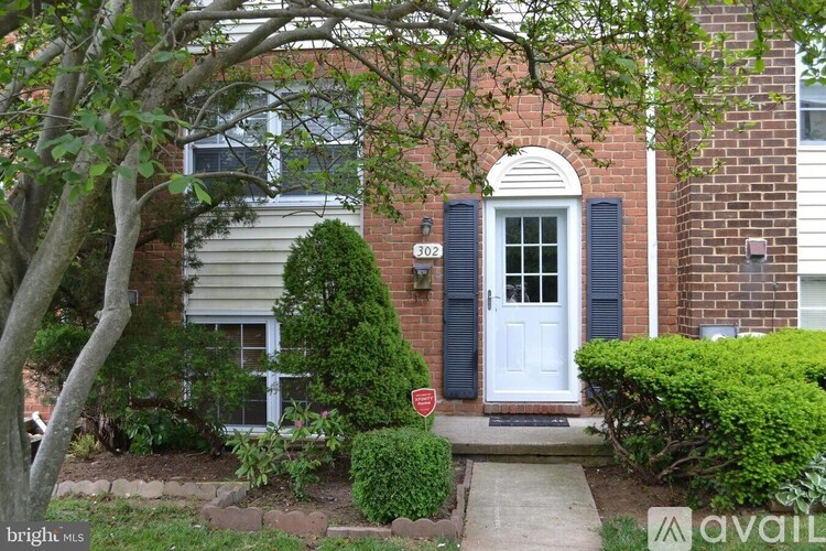 A house with a white door and black shutters is for sale.