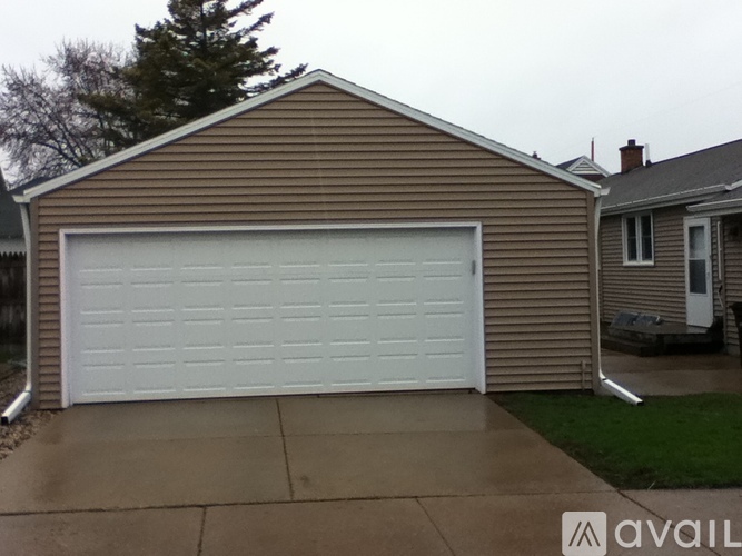 A garage door is closed and the wall is brown.