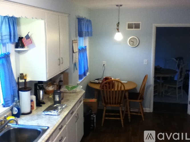 A kitchen with a dining table and chairs.