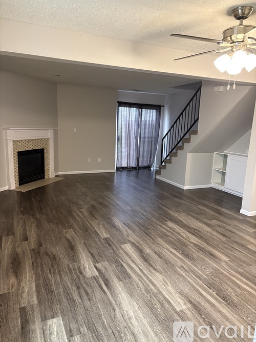 A living room with a fireplace and a staircase.