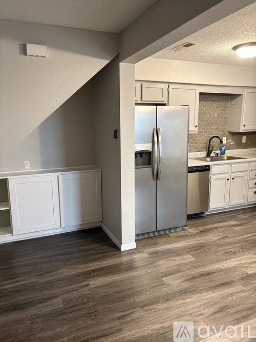 A kitchen with a refrigerator and cabinets.