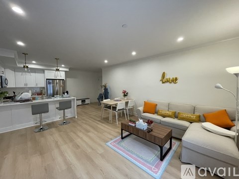 A living room with a white couch and a coffee table in front of a wall with the word "love" written on it.