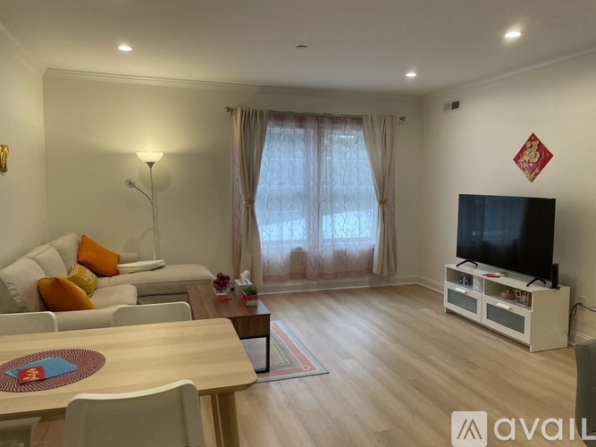 A living room with a television, sofa, and dining table.