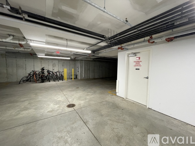 A bicycle is parked in a concrete garage with a door marked "No Trespassing.".