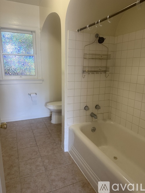 A bathroom with a white tub, toilet and sink.