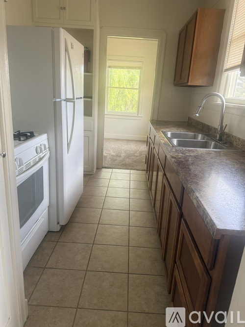 A kitchen with a white refrigerator and a white stove.