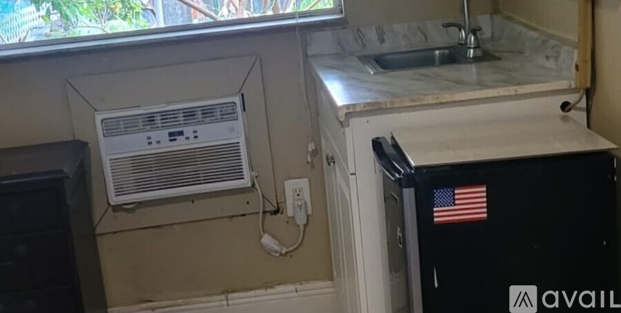 A kitchen with a sink, a window, and an air conditioner unit.