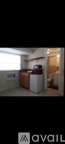 A kitchen with a refrigerator, microwave, and a sink.