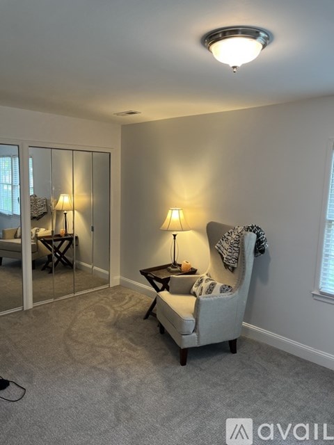 A living room with a grey sofa and a lamp.