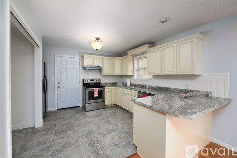 A kitchen with a granite countertop and a stove top oven.