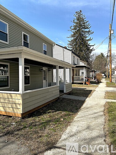 A row of houses with a sidewalk in front.