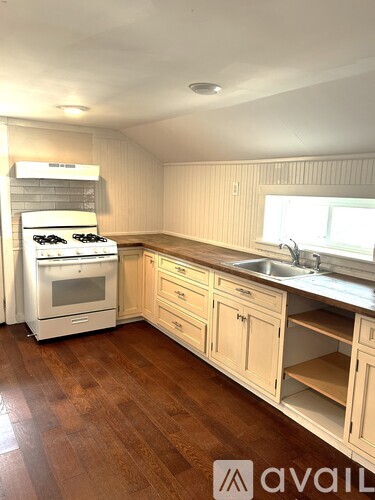 A kitchen with wooden floors and white cabinets.