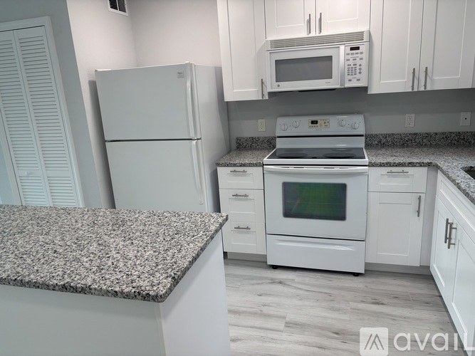 A kitchen with white appliances and cabinets.