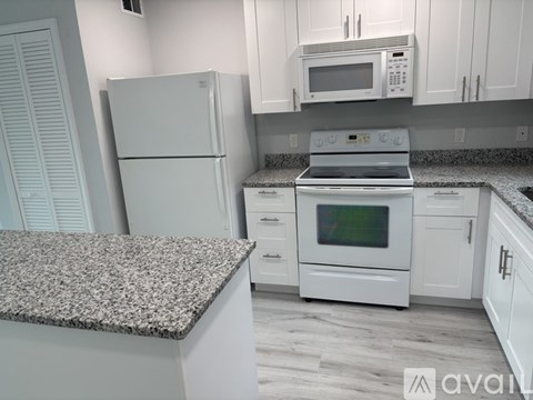 A kitchen with white appliances and cabinets.