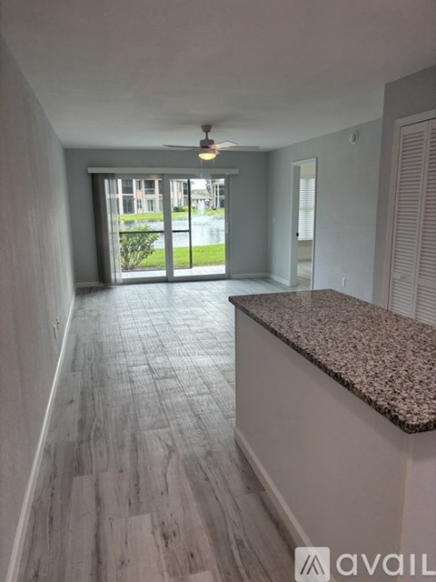 A room with a marble counter and wooden flooring.