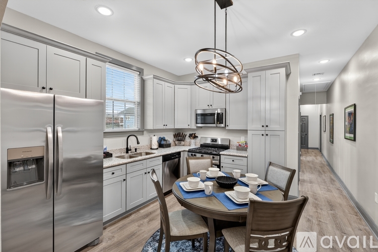 A modern kitchen with a dining table set for two.