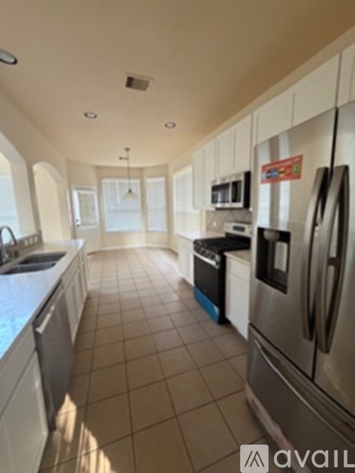 A kitchen with tile flooring and stainless steel appliances.