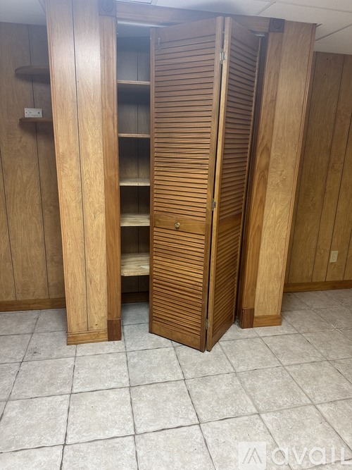 A wooden wardrobe with two doors open.