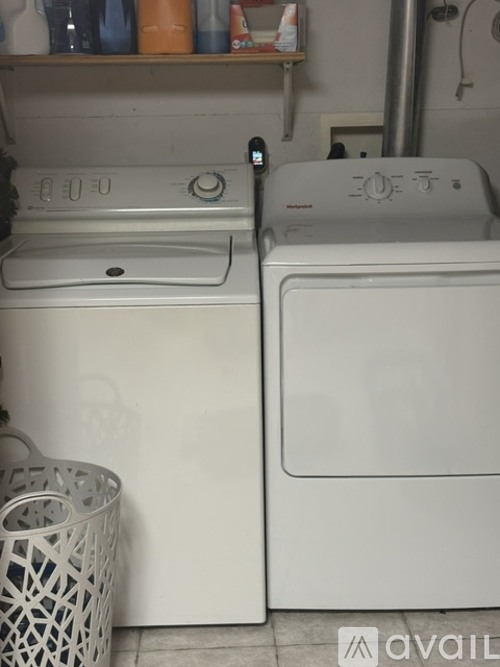 Two white front loading washing machines in a laundry room.