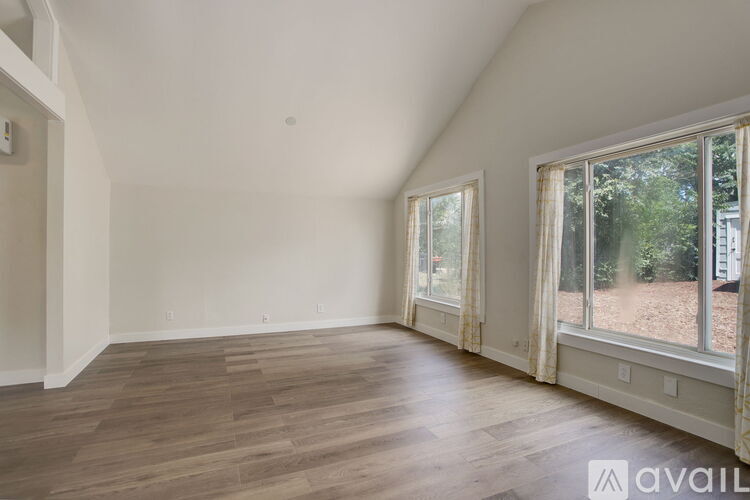 A room with a window and wooden flooring.