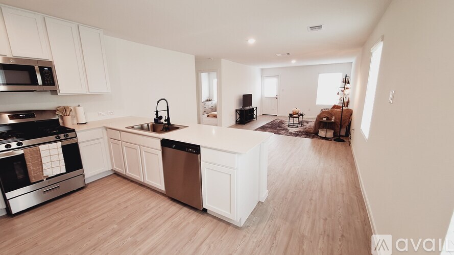 A kitchen with white cabinets and a stainless steel stove top oven.