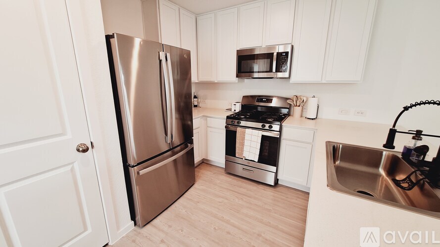 A kitchen with a stainless steel refrigerator, microwave, oven, and sink.