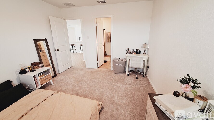 A bedroom with a bed, desk, and chair.