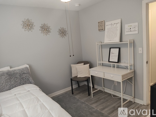 A bedroom with a bed, desk, and chair.