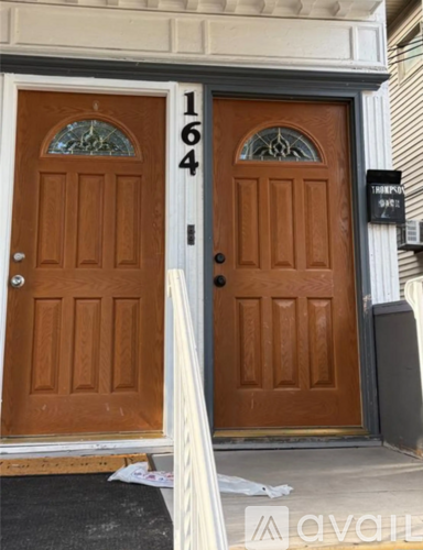 A brown door with the number 164 on it.