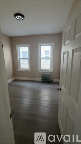 A room with a wooden floor and a white door.
