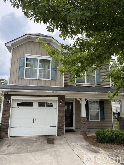 A two-story house with a garage and a driveway.