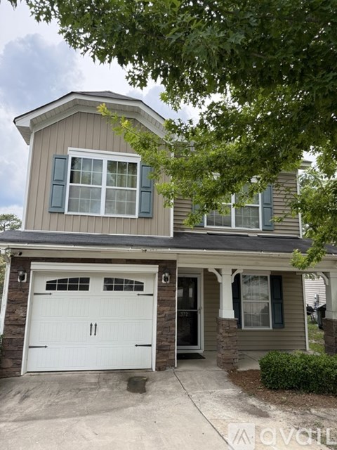 A two-story house with a garage and a driveway.