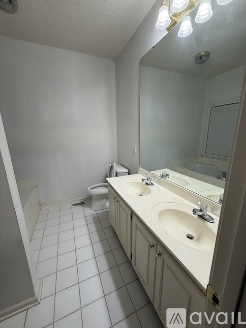 A bathroom with a toilet, sink, and mirror.