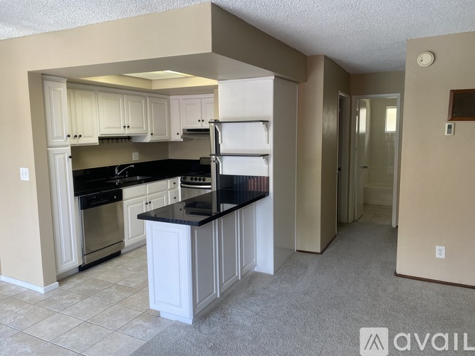 A kitchen with black countertops and white cabinets.