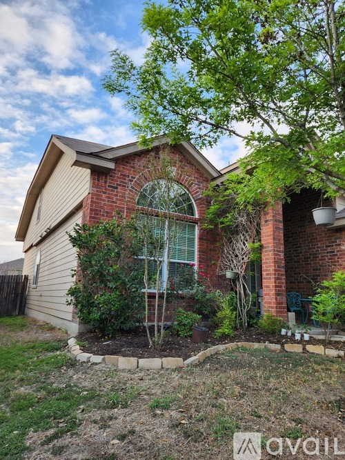 A house with a red brick wall and a large arched window.