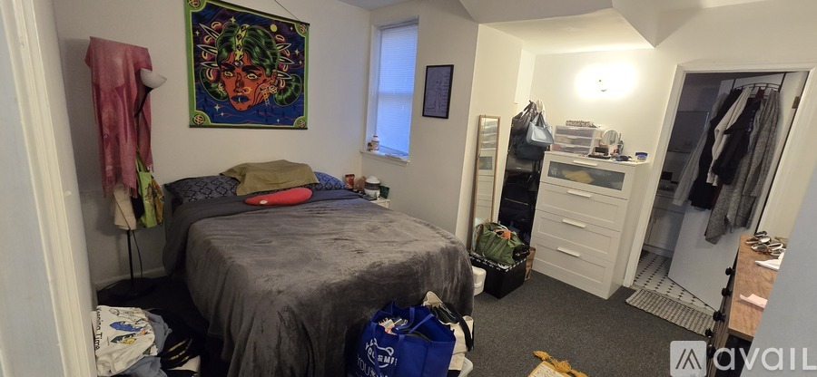 A bedroom with a bed, wardrobe and a painting on the wall.