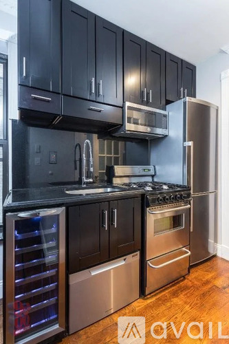 A kitchen with black cabinets and stainless steel appliances.