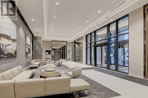 A spacious living room with a white sofa set and a large painting on the wall.