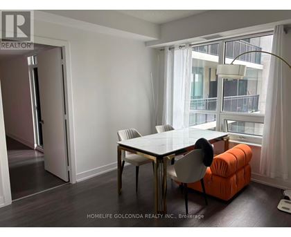 A dining room with a table and chairs and a view of a balcony.